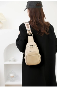 Detalle de bolso bandolera beige con correa tejida estilo bohemio y cremallera doble