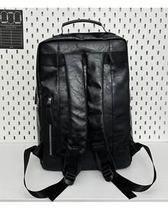 Back view of black leather backpack with padded straps and hidden vertical zipper pocket