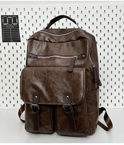 Close-up of vintage brown leather backpack with silver hardware and front buckle pockets