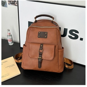 Detail of vintage caramel brown leather backpack with metallic buckle and retro texture
