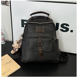 Detail of vintage black PU leather backpack showing top handle and buckle pocket