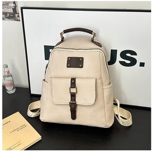 Detail view of vintage off-white faux leather backpack with retro metal buckles and pockets