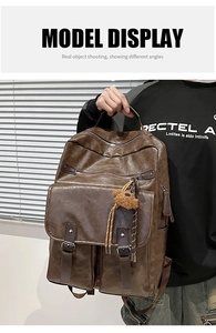 Close-up of vintage dark brown PU leather backpack with multi-zipper layers and bear charm