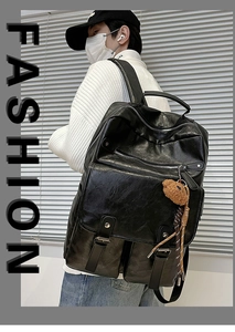 Detail of black faux leather backpack with multiple zipper pockets and bear charm