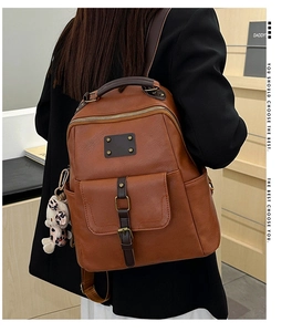 Detail of vintage brown PU leather backpack with buckle strap and front flap pocket