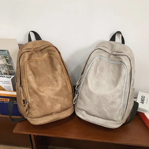 Detail of minimalist brown and grey backpacks featuring large capacity and matte texture