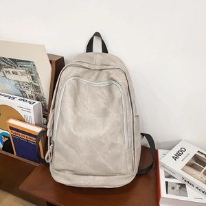 Detail view of large capacity minimalist backpack on a wooden table with books