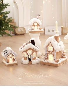 Set of four illuminated gingerbread houses with snow roofs and festive candy decorations