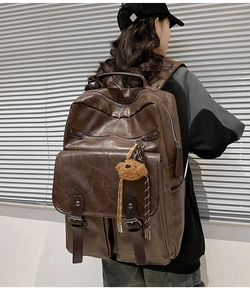 Side view of dark brown retro PU leather backpack with multi-pockets and bear charm