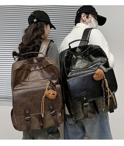 Detail of vintage faux leather backpacks featuring metal buckles and cute bear pendants