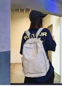 Back view of a large capacity beige travel backpack shown on a model for scale