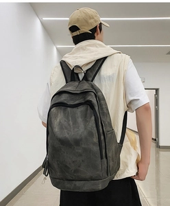 Detailed close-up of dark grey washed canvas backpack featuring durable nylon straps