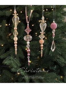 Détail de pendentifs de Noël en acrylique avec perles et billes dorées sur sapin