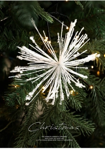 Close-up of sparkling white snowflake ornament with glitter on a lit Christmas tree