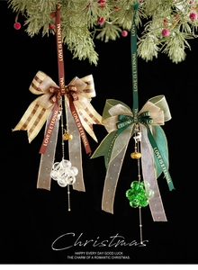 Close-up of festive Christmas bow pendant with crystal drop and gold bell charms