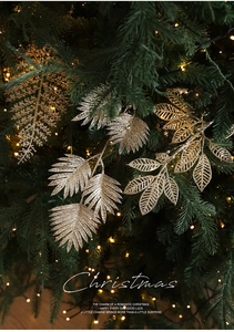 Gros plan de feuilles de fougère dorées à paillettes sur un sapin de Noël décoré