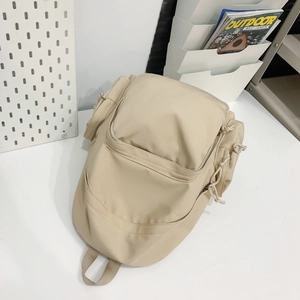 Detail view of multi-pocket nylon backpack in beige color for school and travel