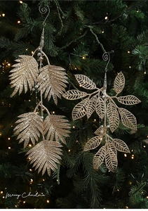 Détail macro de feuilles de fougère dorées à paillettes et pendentifs sur sapin de Noël