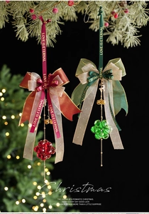 Close-up of crystal Christmas ornaments with love ribbons hanging on a tree branch