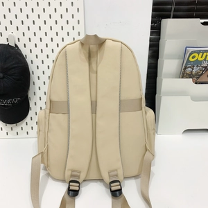 Detail view of khaki nylon backpack back with padded shoulder straps and reflective strips