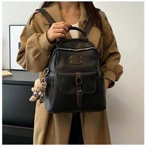 Detail of vintage black faux leather backpack with Hello Kitty charm on model
