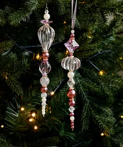 Perles en cristal rose et transparent suspendues au sapin de Noël avec lumières