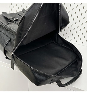 Internal view of black PU leather backpack showing large main compartment and metal zipper