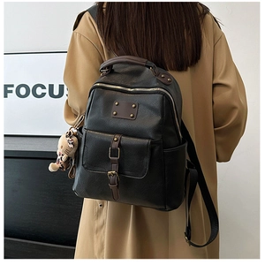 Detail of black pebbled PU leather backpack with magnetic front pocket and leopard charm