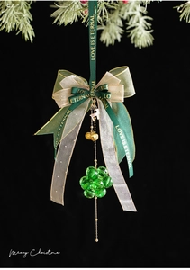 Detail of Christmas bell ornament with green velvet bow, golden deer, and crystal beads