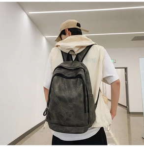 Man wearing deep olive green canvas backpack in a minimalist bright indoor corridor view