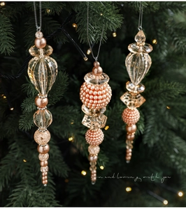 Détail de pendentifs en perles de cristal acrylique rose et or sur un sapin de Noël