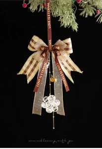 Detail of red and gold ribbon bow with clear crystal beads and gold bell Christmas ornament