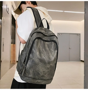 Side view of large grey vintage backpack with wide straps and industrial minimalist design