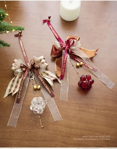 Detailed view of luxury Christmas bow ornaments with bells and deer charms on wood