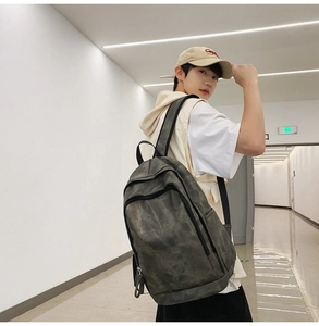 Detail of grey canvas casual backpack showing the spacious main pocket and side pocket