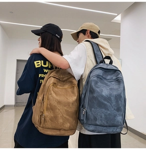 Side view of minimalist camel and navy blue large capacity backpacks on models