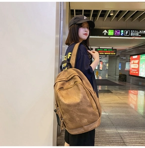 Brown vintage PU leather backpack showing capacity and texture on a female model