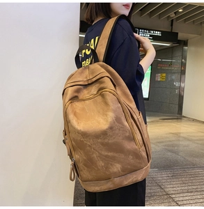 Close-up of brown vintage backpack with multi-zipper layers and matte leather texture