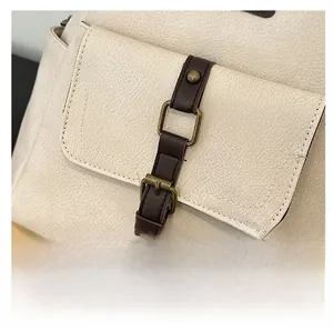 Detailed macro view of vintage bronze hardware buckle on cream lychee pattern leather bag