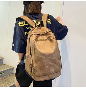 Detailed view of the large brown matte backpack with adjustable straps on model back