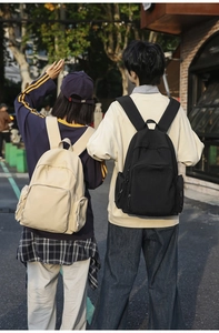 Outdoor shot of minimalist nylon backpacks in beige and black with multi-pocket design