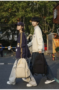 Detail of minimalist nylon campus backpacks featuring side ribbon pockets and large capacity