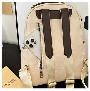 Detail of a beige PU leather backpack featuring a secure rear anti-theft zipper pocket