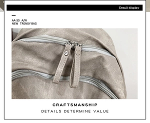 Close-up of a durable beige fabric backpack featuring a sturdy two-way metal zipper design