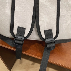 Macro detail of high-quality stitching on adjustable nylon backpack straps with buckles
