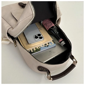 Top view showing large interior capacity of the beige leather backpack with daily essentials