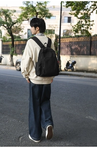 Minimalist black nylon backpack showing large capacity and stylish outdoor street wear look