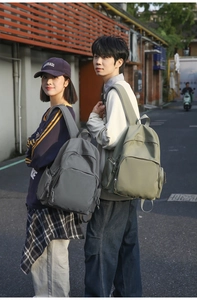 Outdoor shot of students wearing large capacity nylon backpacks in grey and olive green