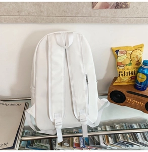 Detailed back view of white school backpack featuring adjustable straps and hidden zipper pocket