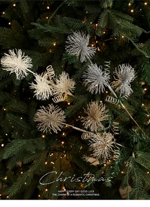 Close-up of glittered Christmas tree picks in silver and gold with warm led lights